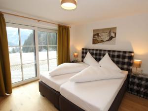 a bedroom with two beds and a large window at Modern chalet with sauna near ski area in Saalbach Hinterglemm Salzburgerland in Saalbach-Hinterglemm