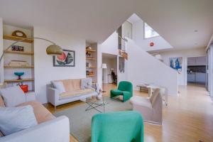 uma sala de estar cheia de mobiliário e uma escadaria em La Parenthèse Bordelaise - Maison d'architecte avec piscine em Le Bouscat