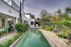 勒布斯卡的住宿－La Parenthèse Bordelaise - Maison d'architecte avec piscine，一座房子后院的游泳池