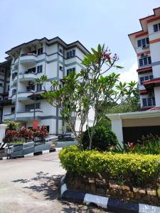 a large white building with a tree in front of it at 3 Bedrooms 2 Bathrooms Seruni Apartment, Serendah Gold Resort, Persiaran Meranti Selatan, Ulu Selangor, 48200 in Serendah