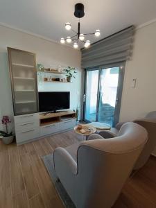 a living room with a couch and a tv at Sotherm apartment in Thermi