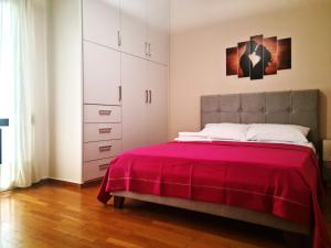 - une chambre avec un lit et une couverture rouge dans l'établissement Comfortable Apartment in Athens Kallithea, à Athènes