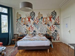 1 dormitorio con 1 cama con un mural floral en la pared en Domaine de l'Oie Rouge, en Les Rosiers