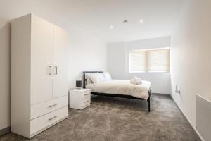 een witte slaapkamer met een bed en een witte kast bij Fantastic Central Doncaster 1 Bedroom Apartment in Doncaster