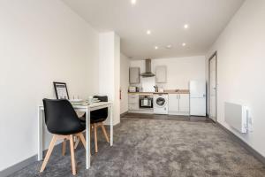 a kitchen with a table and chairs in a room at Fantastic Central Doncaster 1 Bedroom Apartment in Doncaster