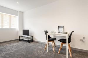 een kamer met een tafel, 2 stoelen en een bureau bij Fantastic Central Doncaster 1 Bedroom Apartment in Doncaster