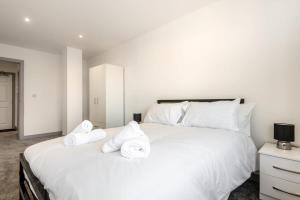 ein Schlafzimmer mit einem großen weißen Bett mit Handtüchern darauf in der Unterkunft Fantastic Central Doncaster 1 Bedroom Apartment in Doncaster