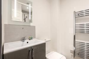 a white bathroom with a sink and a mirror at Fantastic Central Doncaster 1 Bedroom Apartment in Doncaster