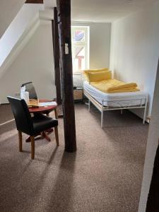 a bedroom with a bed and a desk and a chair at Pension Hansehof in Salzwedel