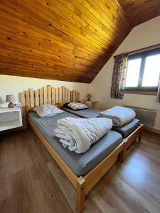 two beds in a room with a wooden ceiling at Refuge de la banne in Murat-le-Quaire