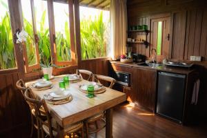 eine Küche mit einem Holztisch mit Stühlen und einem Waschbecken in der Unterkunft Kayu Village in Canggu