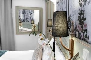 sypialnia z łóżkiem, lampką i lustrem w obiekcie Hotel Boutique Las Almenas w Grenadzie