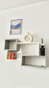 een witte plank met een foto en een vaas erop bij Luxury apartment with view (1min from lake/center) in Como