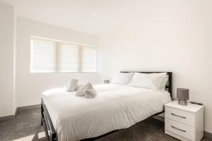 een witte slaapkamer met een groot bed en een raam bij Bright 1 Bedroom Apartment in Central Doncaster in Doncaster