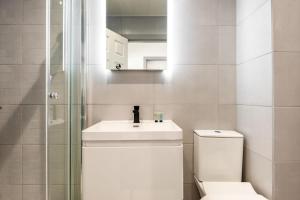 a bathroom with a toilet and a sink and a mirror at Bright 1 Bedroom Apartment in Central Doncaster in Doncaster