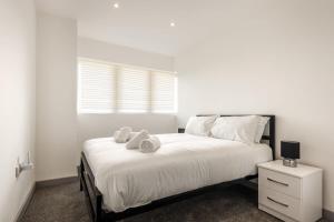 - une chambre avec un lit avec deux animaux rembourrés dans l'établissement Comfortable 1 Bedroom Central Doncaster Apartment, à Doncaster