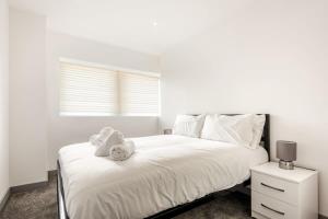 - une chambre blanche avec un lit et des serviettes dans l'établissement Lovely 1 Bedroom Apartment in Central Doncaster, à Doncaster