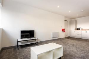 a white living room with a tv and a table at Lovely 1 Bedroom Apartment in Central Doncaster in Doncaster