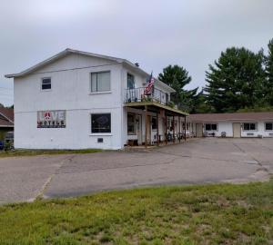 Ein altes weißes Gebäude mit amerikanischer Flagge. in der Unterkunft Love Hotels Tomahawk at Lake Mohawksin WI in Tomahawk