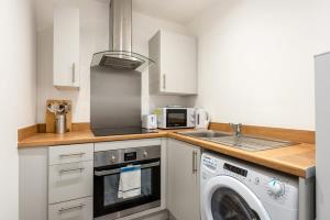 een keuken met een wasmachine en een wastafel bij Comfortable Studio Apartment in Central Doncaster in Doncaster