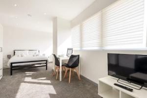 een woonkamer met een televisie en een tafel en stoelen bij Comfortable Studio Apartment in Central Doncaster in Doncaster