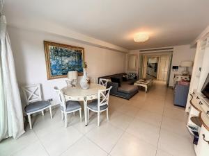 een woonkamer met een tafel en stoelen bij Direct view to the red carpet, 2 bedroom 311 in Cannes