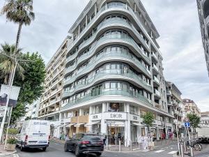 een hoog gebouw met een busje ervoor geparkeerd bij Direct view to the red carpet, 2 bedroom 311 in Cannes