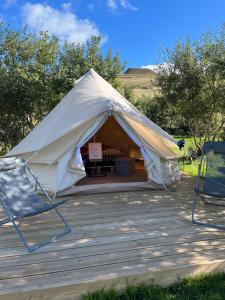 a white tent with two chairs and a table at Refuge de la banne in Murat-le-Quaire
