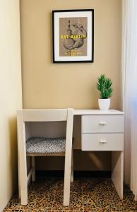 a desk with a chair and a picture on the wall at Bononia Host - Beverara in Bologna