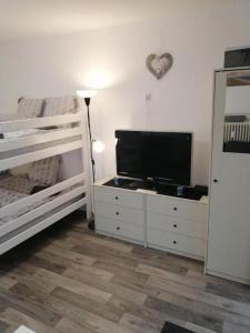 ein Schlafzimmer mit Flachbildfernseher und zwei Etagenbetten in der Unterkunft FEWO Kutsch Watt Nr.3 in Cuxhaven + 9 Fotos