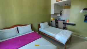 2 Betten in einem kleinen Zimmer mit Küche in der Unterkunft ZH Studio Apartment Gua Musang in Gua Musang