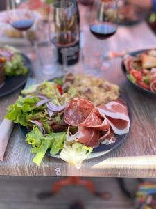 a plate of food with a salad and pizza on a table at Refuge de la banne in Murat-le-Quaire