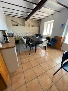 a man sitting at a table in a room with a kitchen at Albergue El Alfar/Pilgrim Hostel in Hornillos del Camino