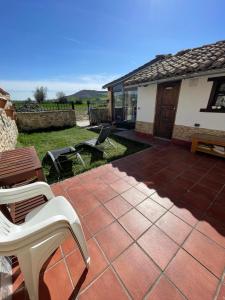 a patio with chairs and a table and a house at Albergue El Alfar/Pilgrim Hostel in Hornillos del Camino