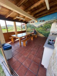 un hombre sentado en una mesa de madera en una cocina en Albergue El Alfar/Pilgrim Hostel, en Hornillos del Camino