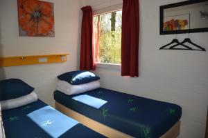 een slaapkamer met 2 aparte bedden en een raam bij Vakantiehuis Rosa in Simpelveld