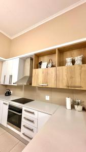 una cocina con armarios blancos y electrodomésticos blancos en Upmarket apartment in the heart of Windhoek, en Windhoek