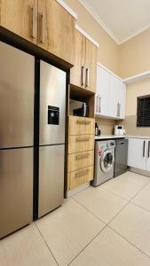 cocina con nevera y lavadora en Upmarket apartment in the heart of Windhoek, en Windhoek