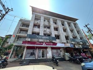 a building on a street with motorcycles parked in front at Hotel Aaba's Gomantak in Sawantwadi