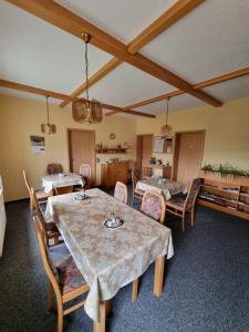 comedor con mesas y sillas y cocina en Pension Schmidt, en Bad Kösen