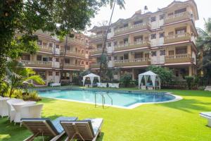 a large apartment building with a swimming pool in a yard at 2bhk with Swimming pool & Kitchen in Candolim