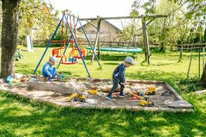 zwei junge Jungs spielen mit Spielzeug in einem Sandkasten in der Unterkunft Meisterbauerhof in Ainring