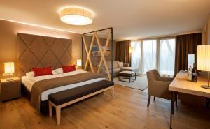 ein Hotelzimmer mit einem großen Bett und einem Schreibtisch in der Unterkunft Almwellness Hotel Pierer in Fladnitz an der Teichalm