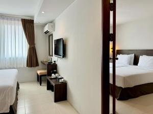 een hotelkamer met een bed en een televisie bij Pas Cher Hotel de Bangkok in Bangkok