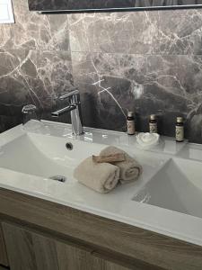 um lavatório de casa de banho com uma toalha em A Casa da Corsica em Pêro Moniz