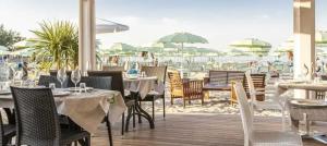 a restaurant with tables and chairs and a beach at Appartamento in Villa in Pesaro