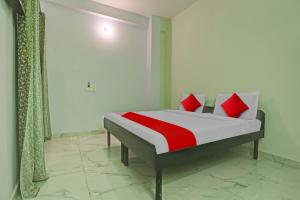 een slaapkamer met een bed met rode en witte kussens bij OYO Flagship Hotel Arya Residency in Gurgaon