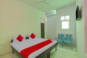 een slaapkamer met een bed en twee blauwe stoelen bij OYO Flagship Hotel Arya Residency in Gurgaon