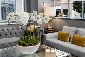 uma sala de estar com um sofá e um vaso com flores brancas em Hotel Boutique Las Almenas em Granada