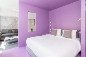- une chambre violette avec un grand lit et un canapé dans l'établissement Athens Color Cube, à Athènes